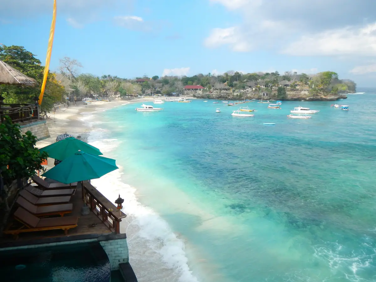 A curve of white sand and turquoise water along a bay on Nusa Lembongan, seen from above